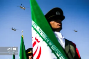 Soldier of Iran with a flag of the country, and helicopters behind him