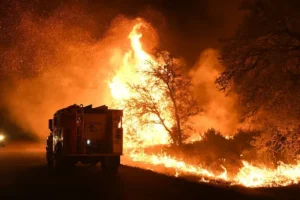 Fire truck moving next to a wildfire in Texas.