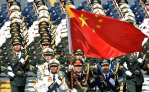 Chinese troops marching with a flag of China.