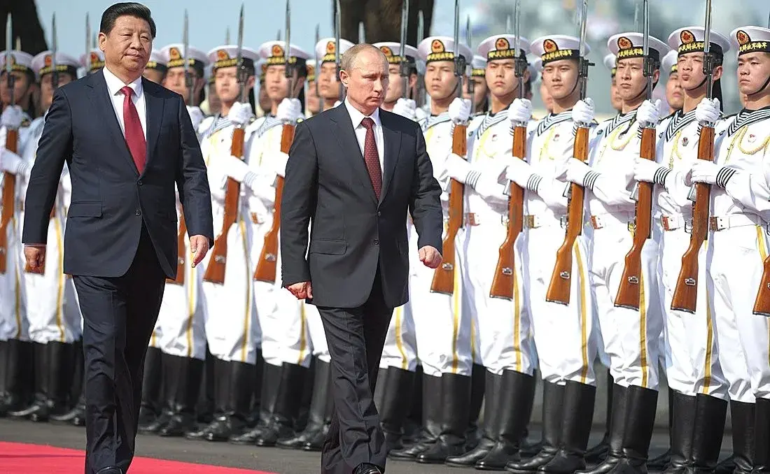 Xi Jinping and Vladimir Putin walking in front of Chinese Navy soldiers.