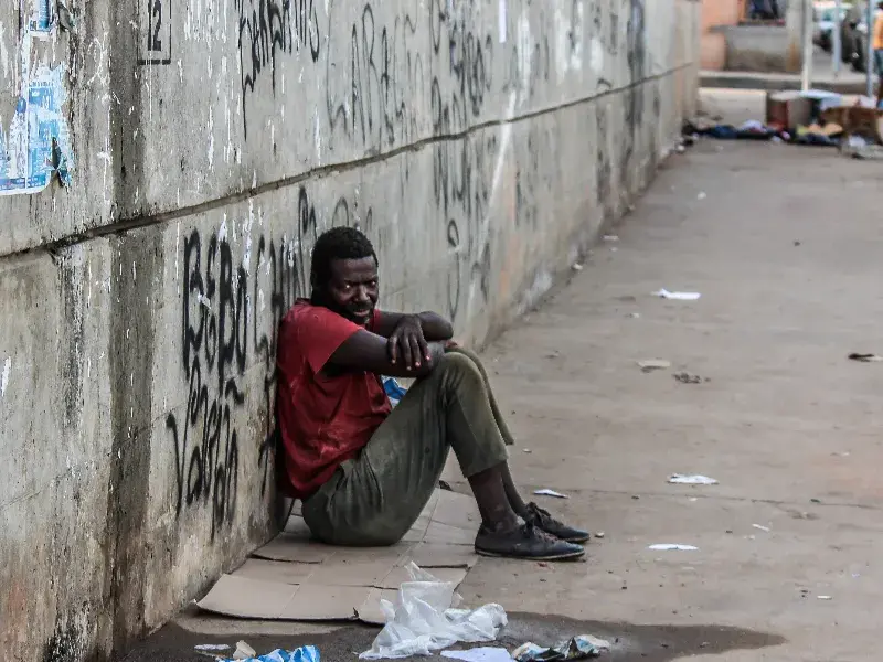 African man sitting alone in the street.
